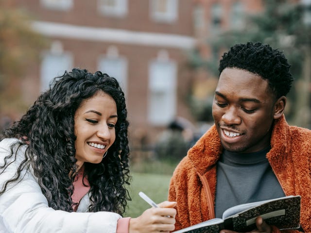 Dos amigos estudiando en el jardín lo que aprendieron en el mejor centro de idiomas de México.