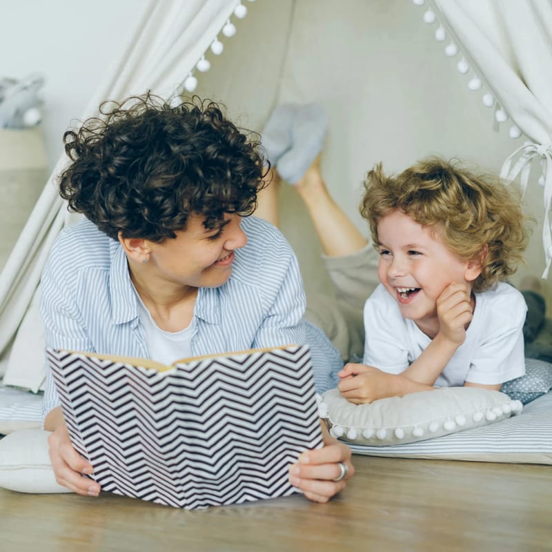 Madre contándole a su pequeño hijo fábulas en inglés