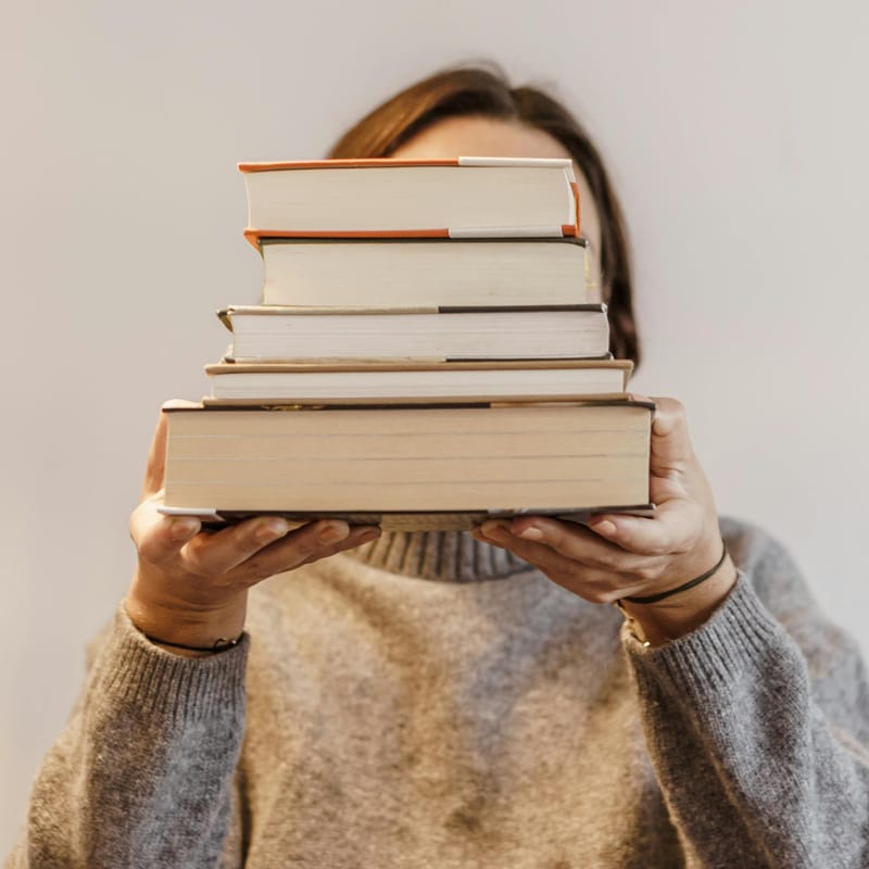 Mujer con libros para aprender a aprender.