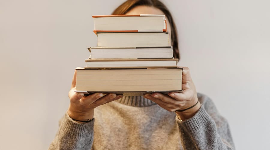 Mujer con libros para aprender a aprender.