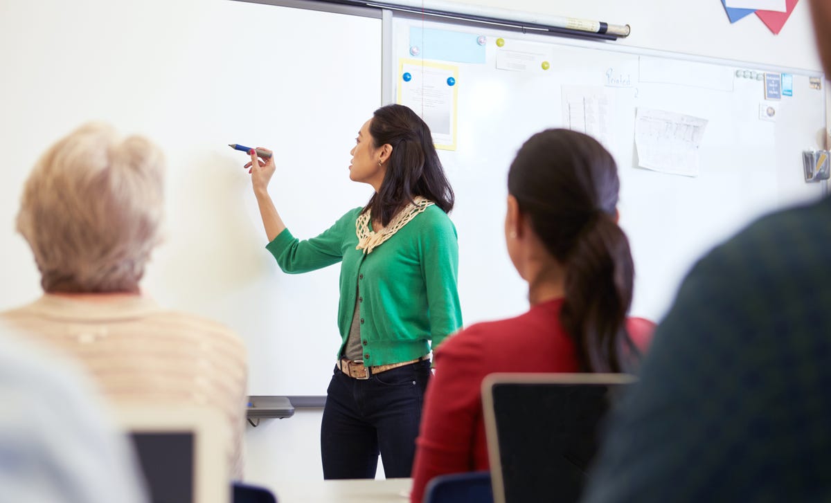 Una mujer escribiendo en un pizarrón